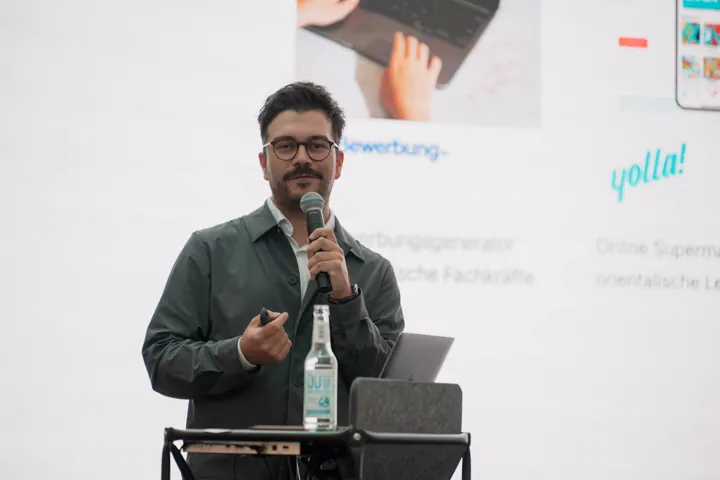 Speaker mit Mikrofon vor der Leinwand