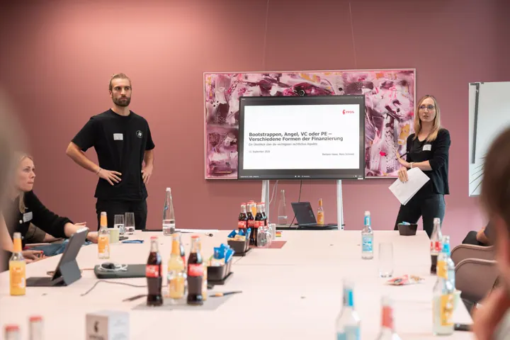 Zwei Personen präsentieren am Tisch