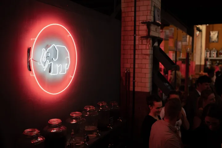 Leuchtendes Mampe-Neonlogo mit Elefant an der Wand